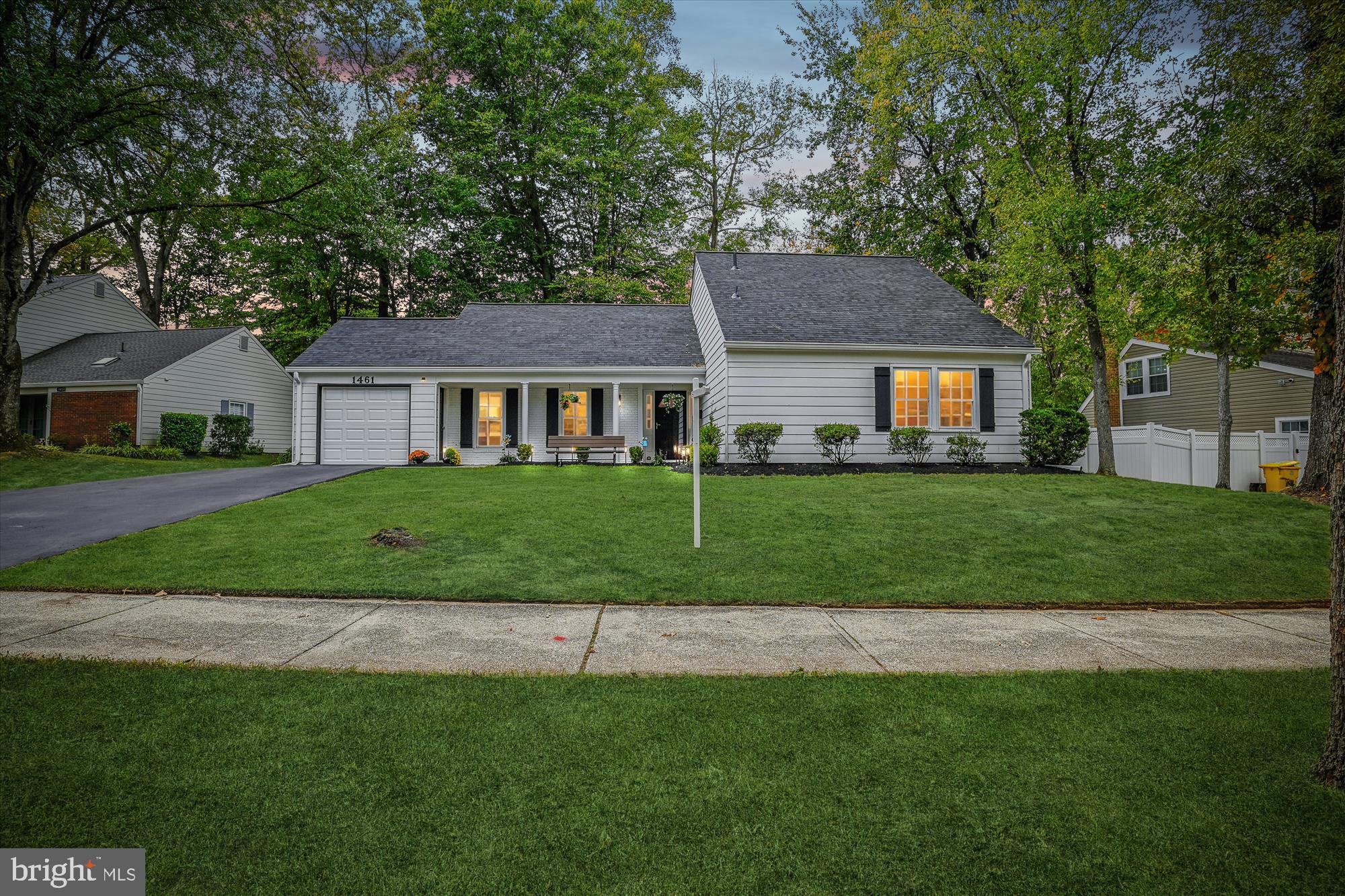 a front view of a house with a yard and trees