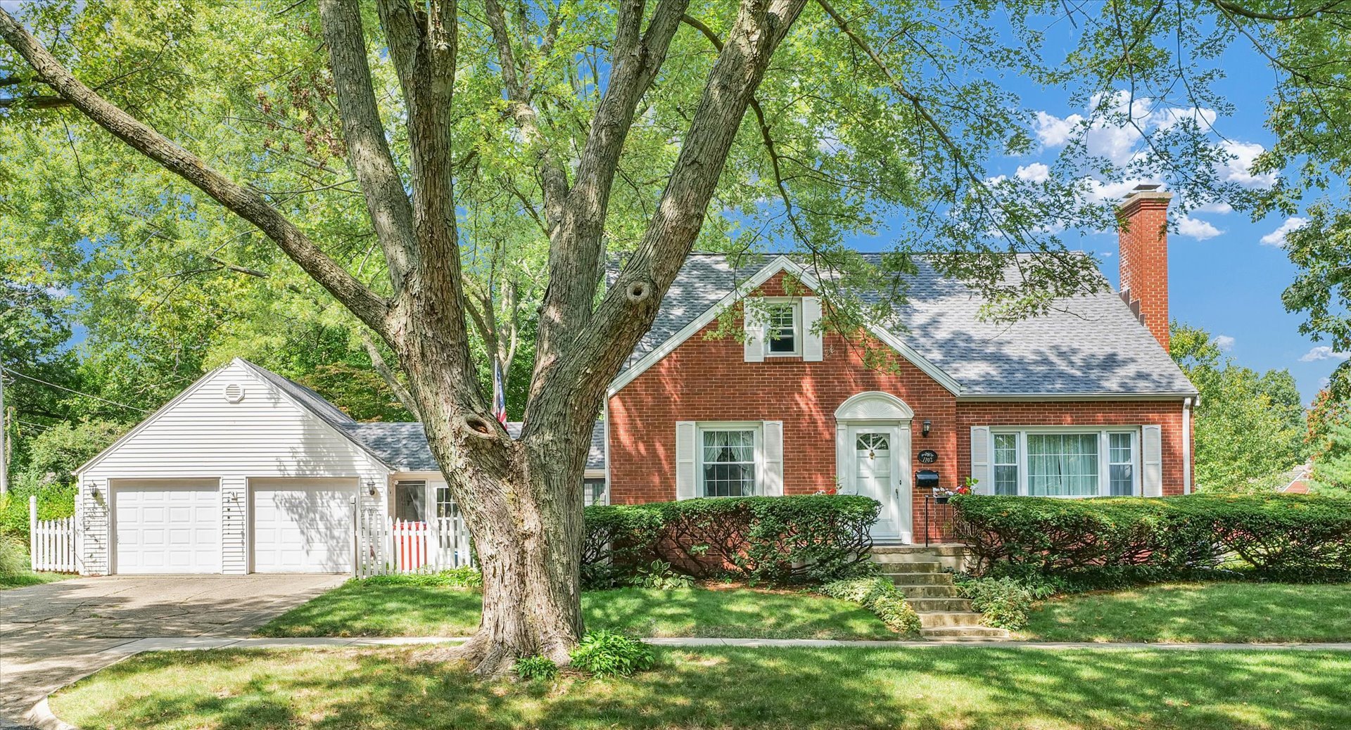 a front view of a house with a yard and potted plants