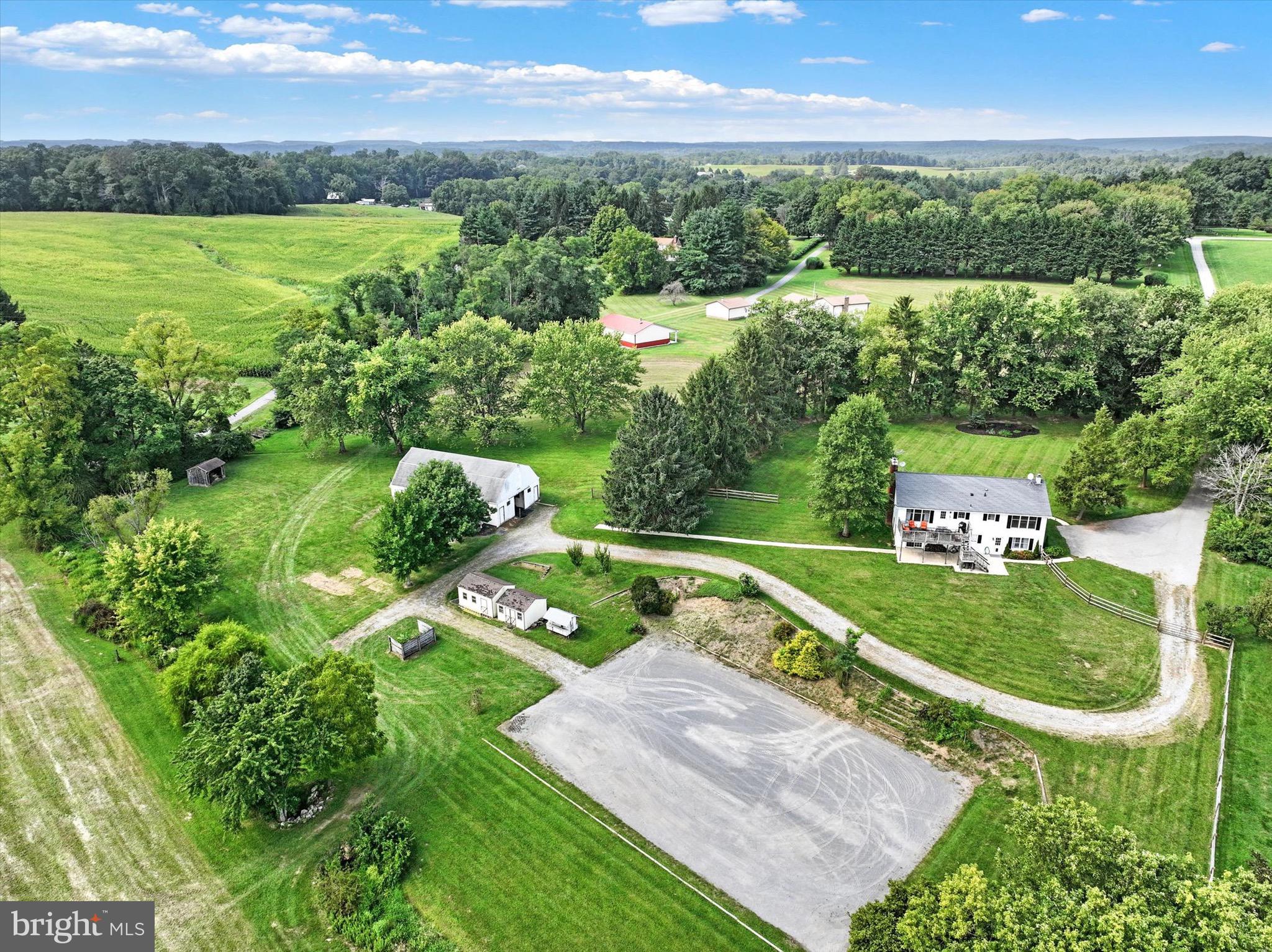 an aerial view of residential houses with outdoor space and trees