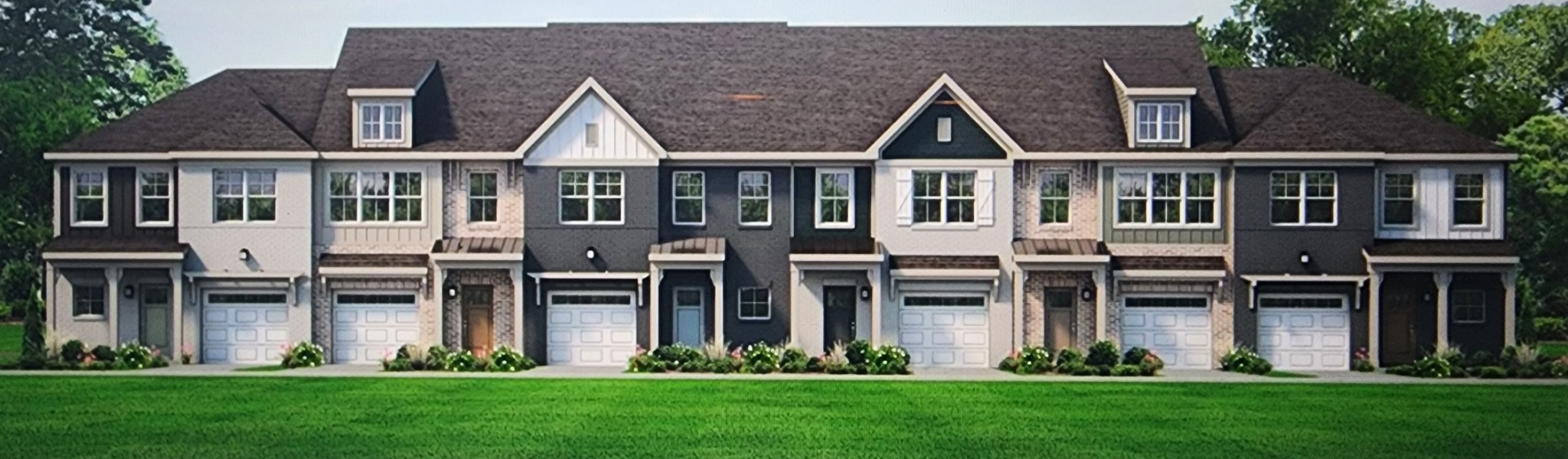 a front view of a house with a yard and plants