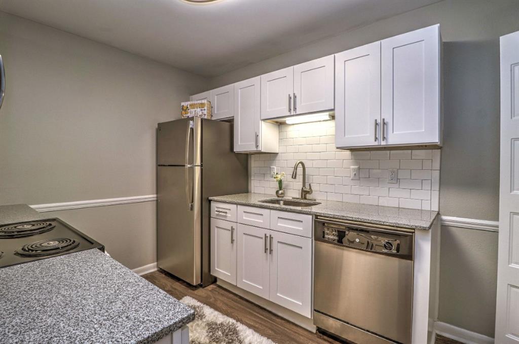 a kitchen with stainless steel appliances granite countertop a stove a refrigerator and a sink