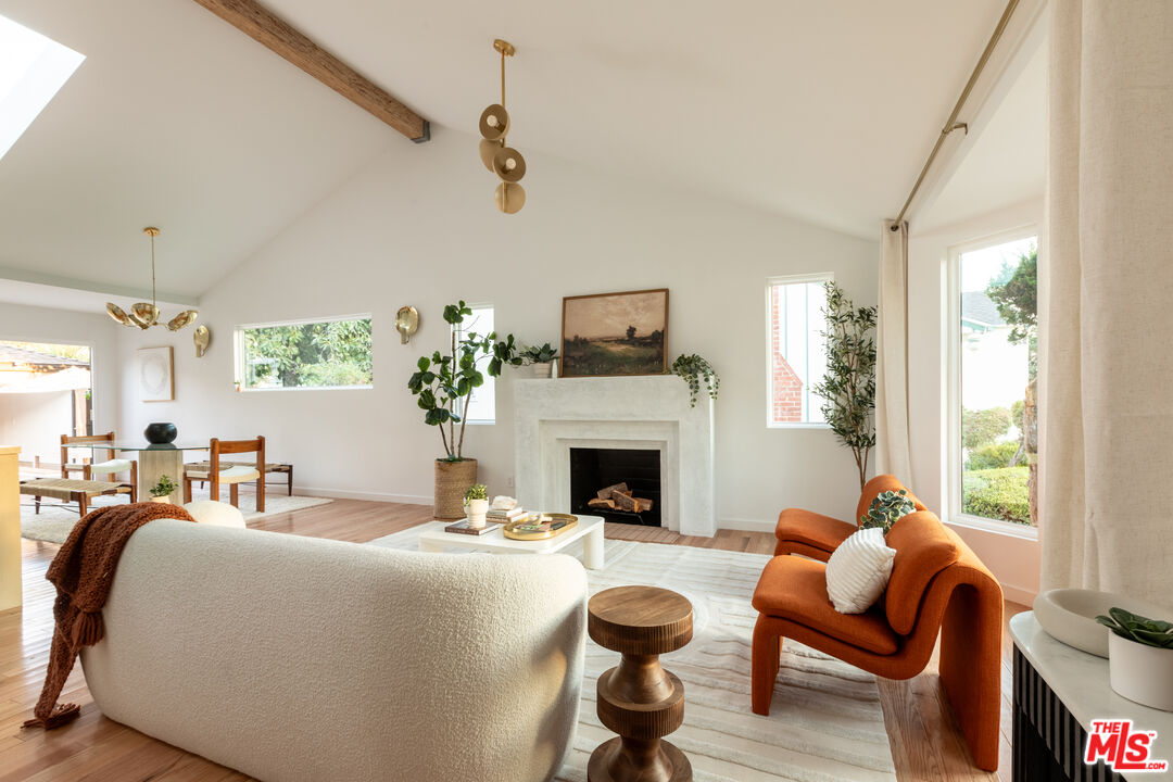 a living room with furniture a fireplace and a large mirror