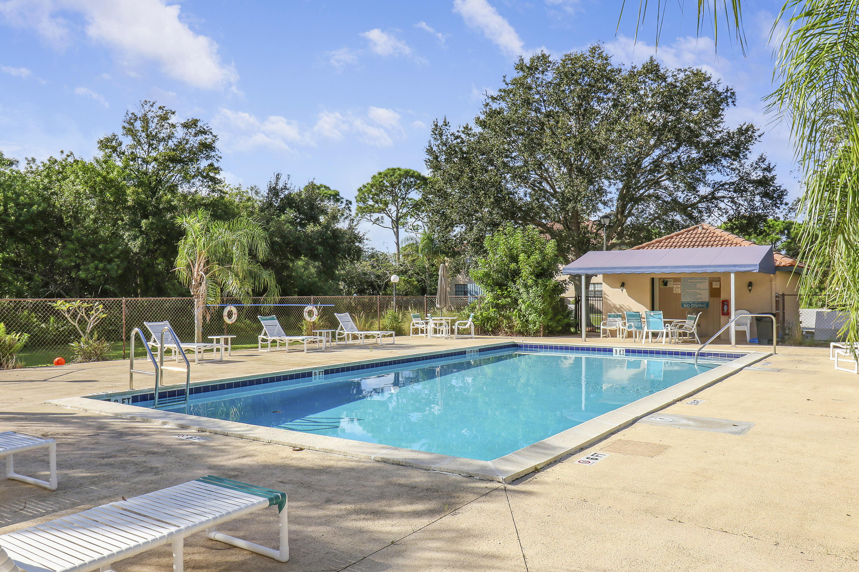 a view of a swimming pool with a table and chairs under an umbrella