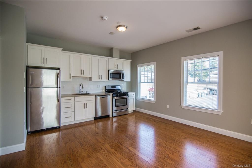 a kitchen with granite countertop white cabinets and stainless steel appliances