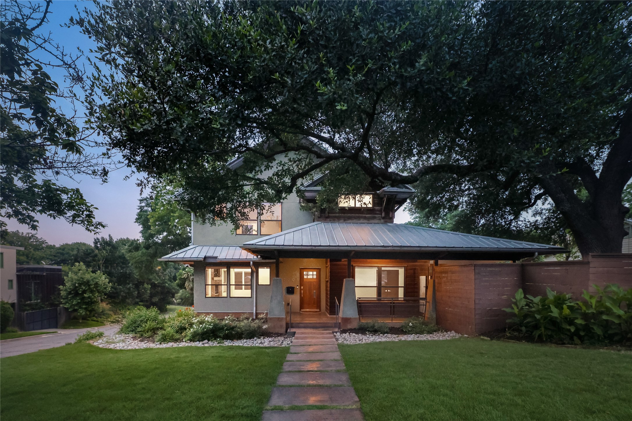 a front view of a house with a yard and garden