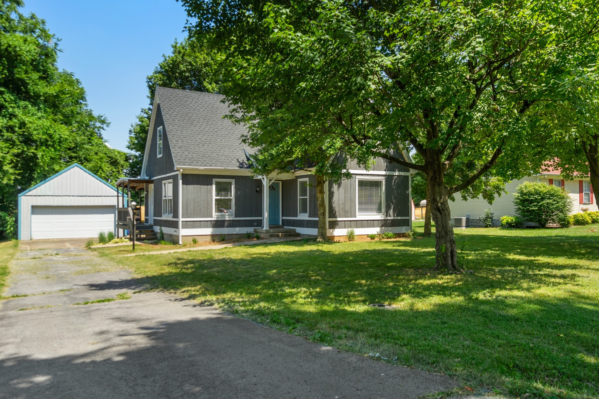 a front view of a house with a garden and trees