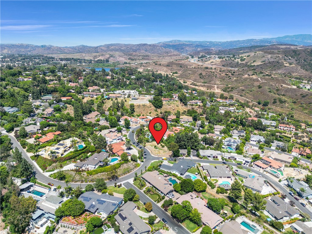 an aerial view of residential houses with outdoor space and parking