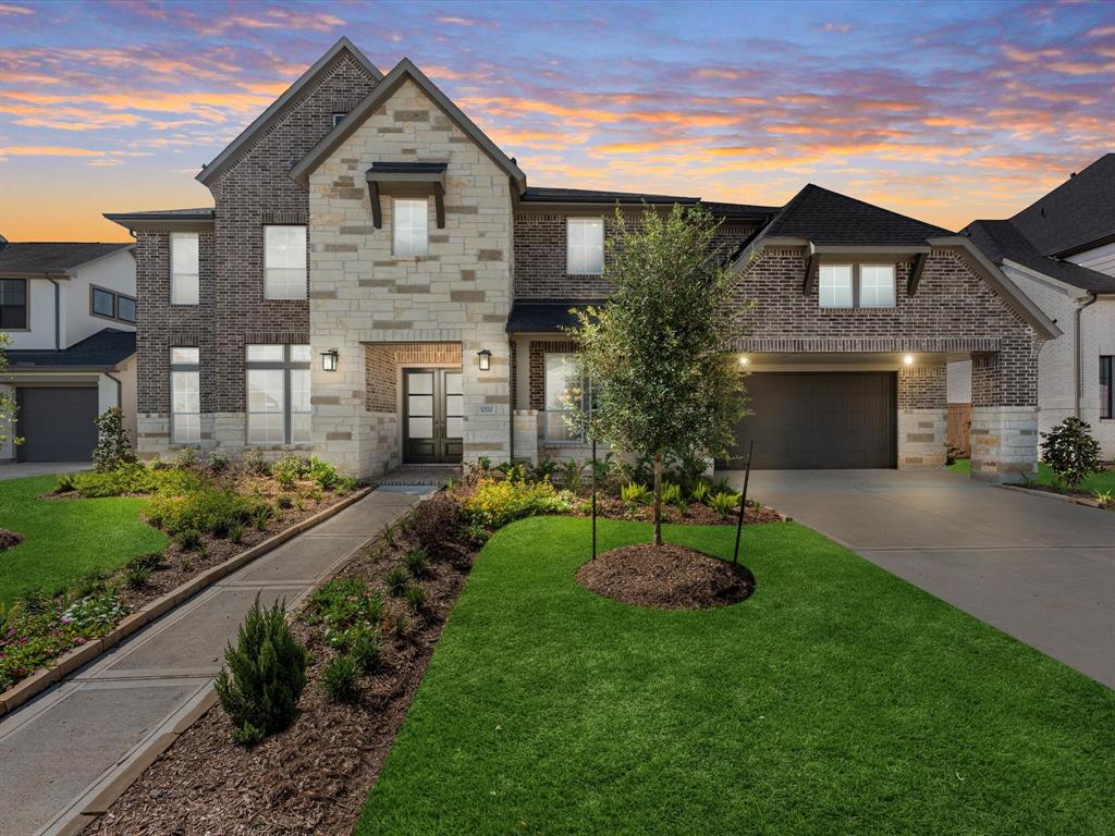 a front view of a house with a yard and green space