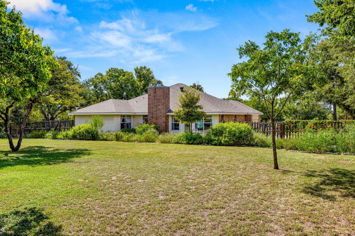 a view of a house with garden and a tree