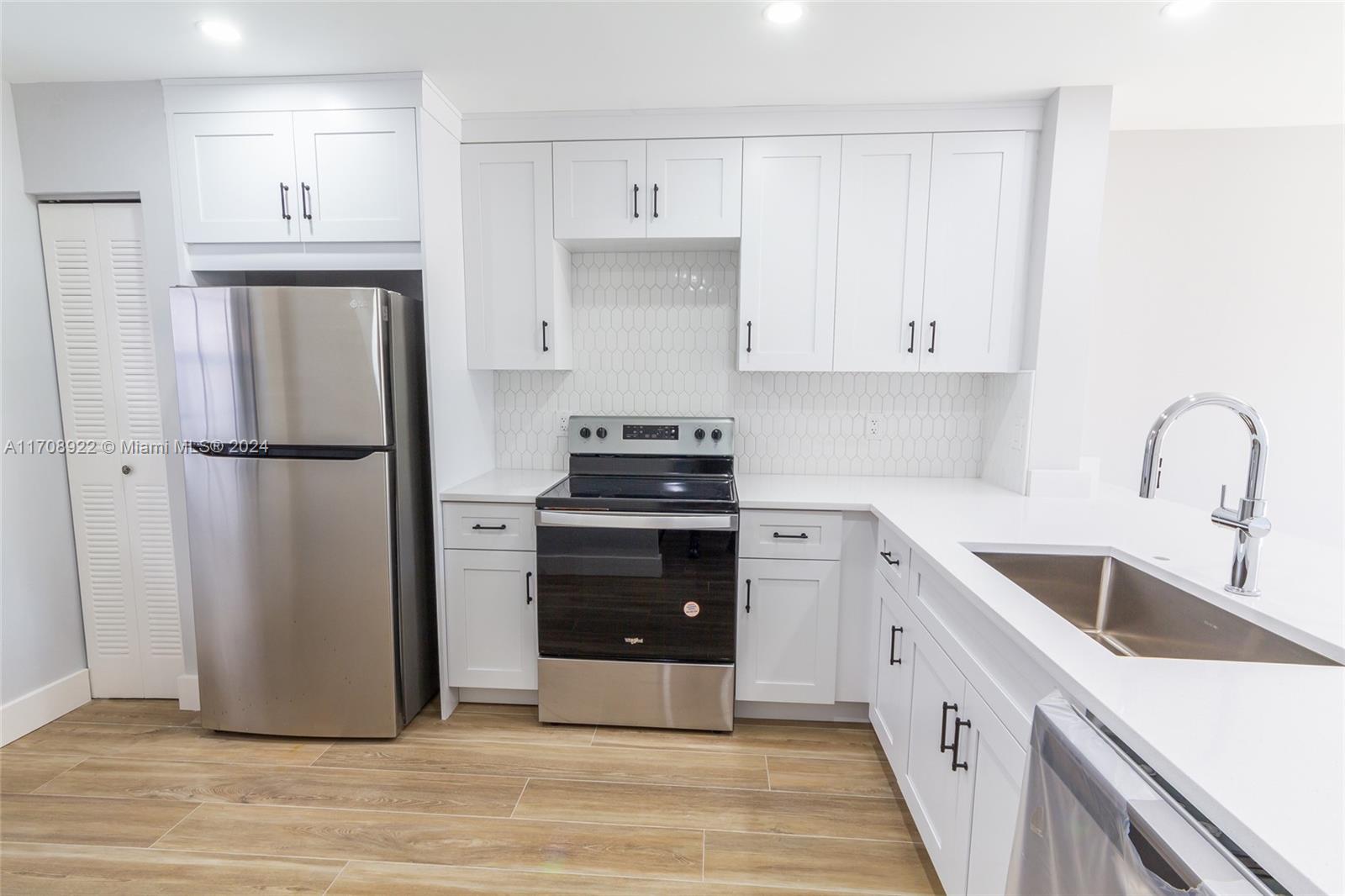 a kitchen with a refrigerator sink and cabinets