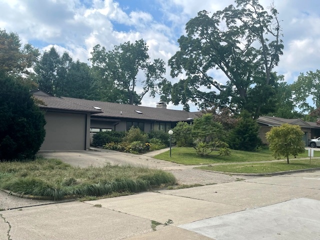 a front view of a house with a yard and trees