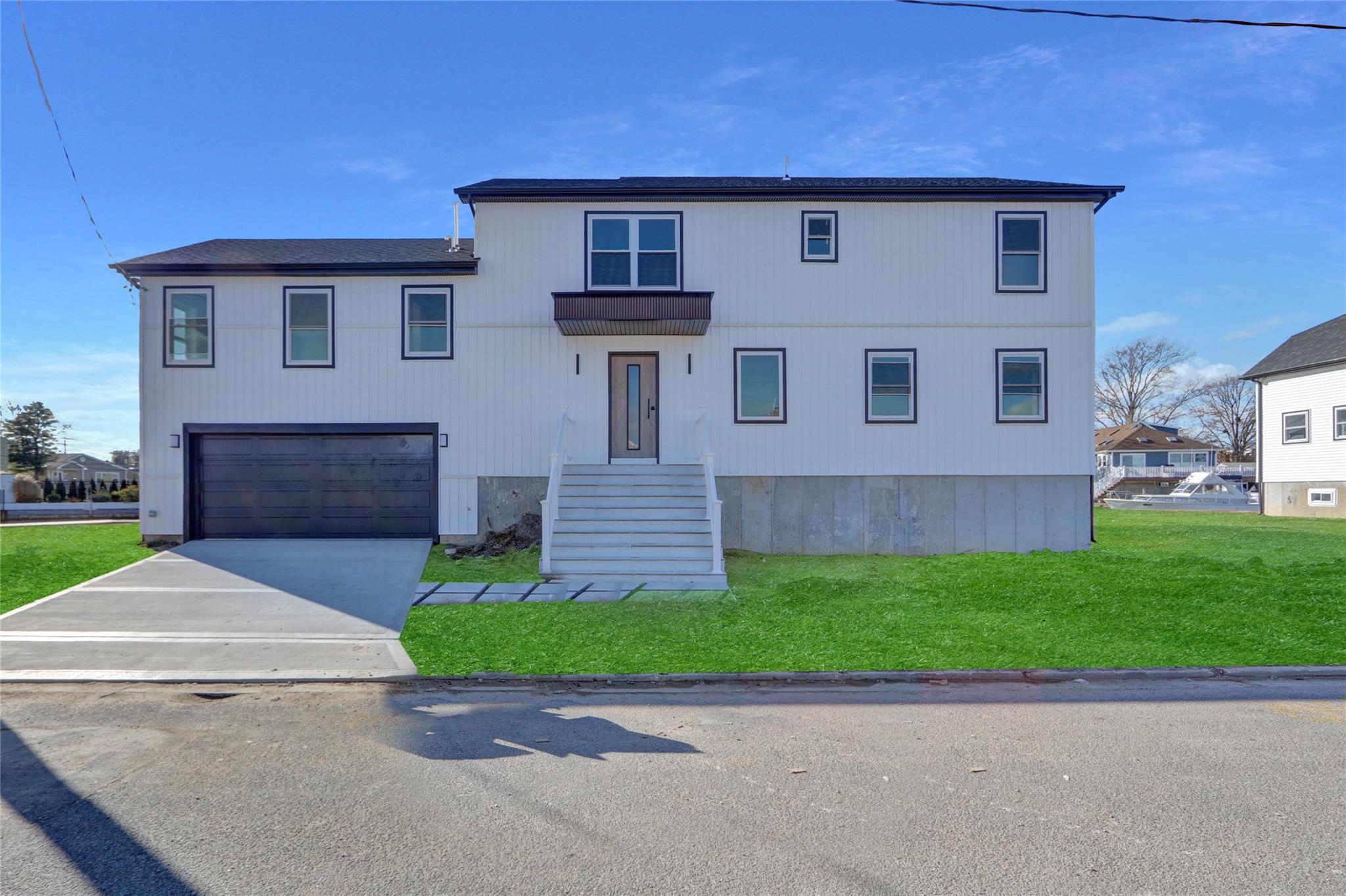 View of front of house with a front yard and a garage