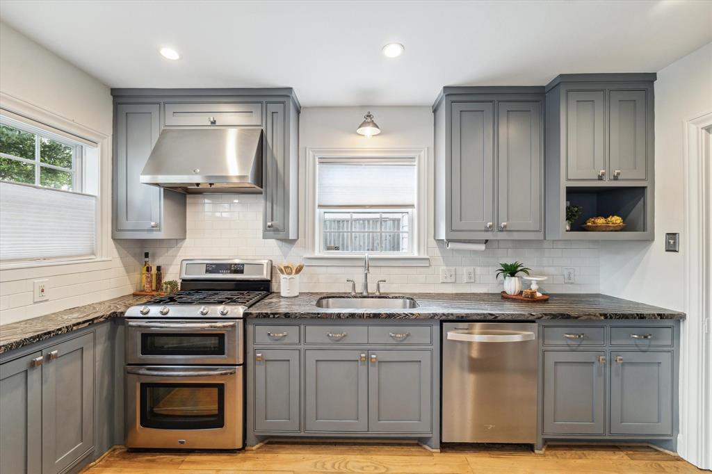 a kitchen with stainless steel appliances a stove sink and cabinets