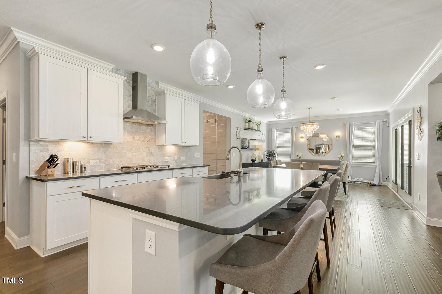 a kitchen with stainless steel appliances granite countertop a sink a stove and a wooden floors