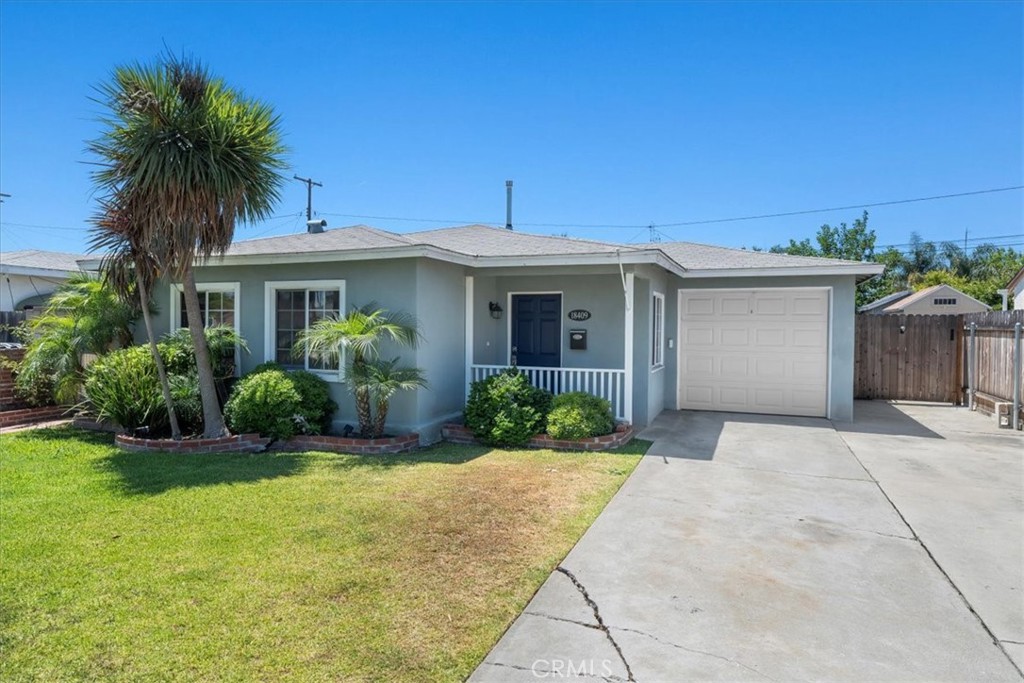 a front view of a house with a yard and potted plants