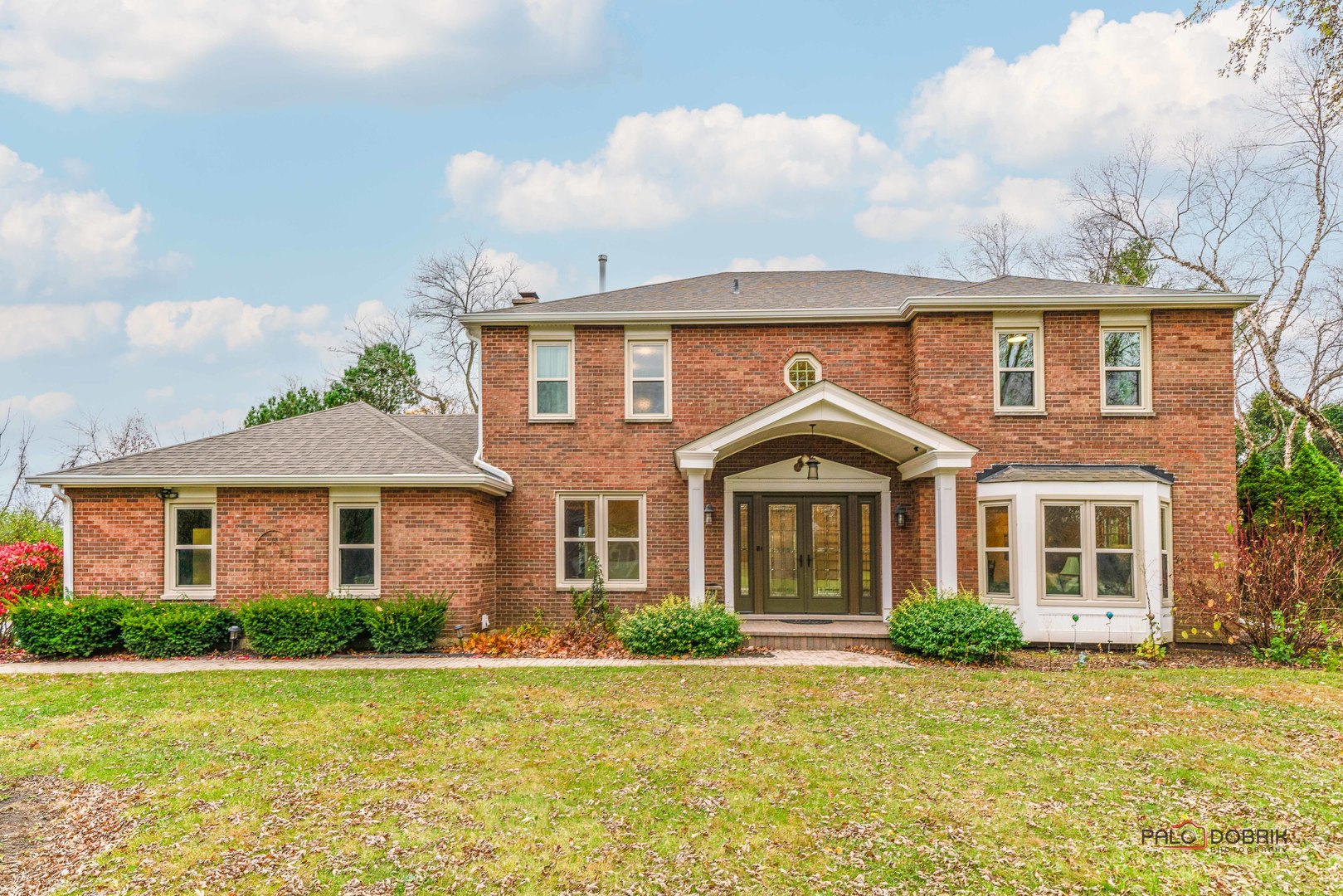 a front view of a house with a garden