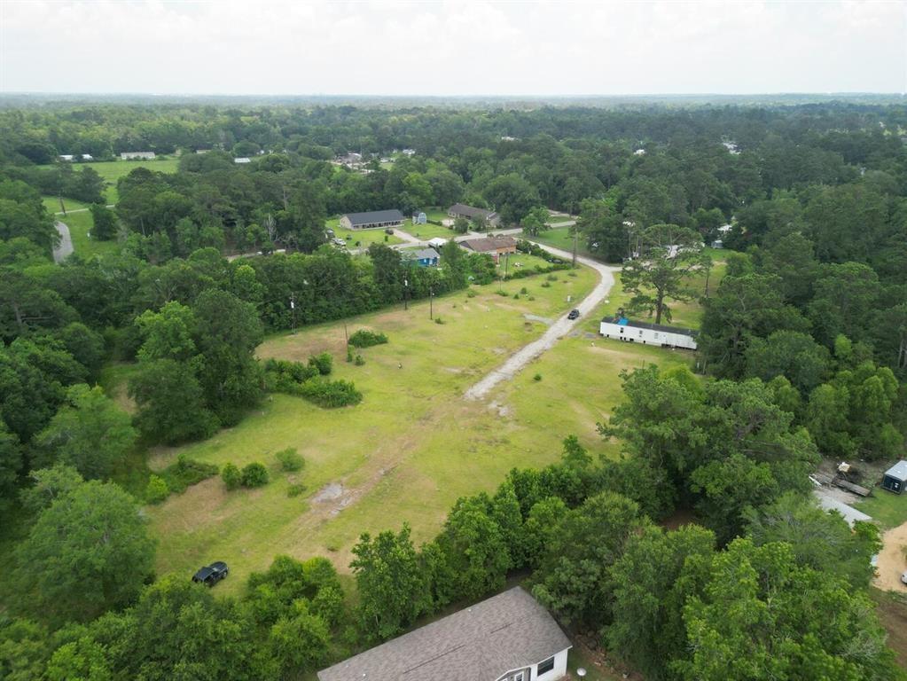 an aerial view of residential houses with outdoor space and trees