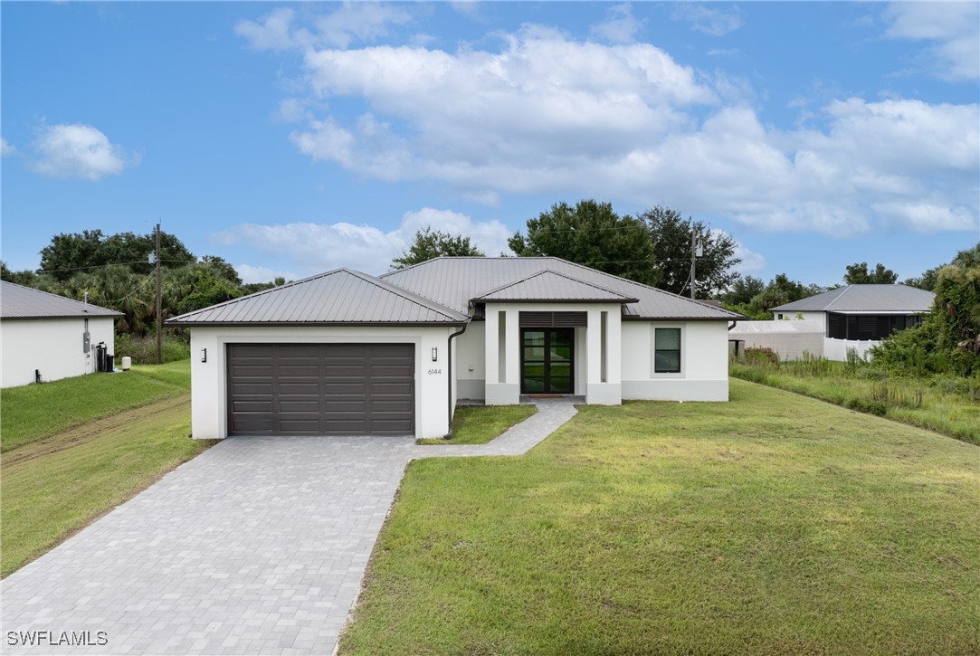 a front view of a house with yard and garage