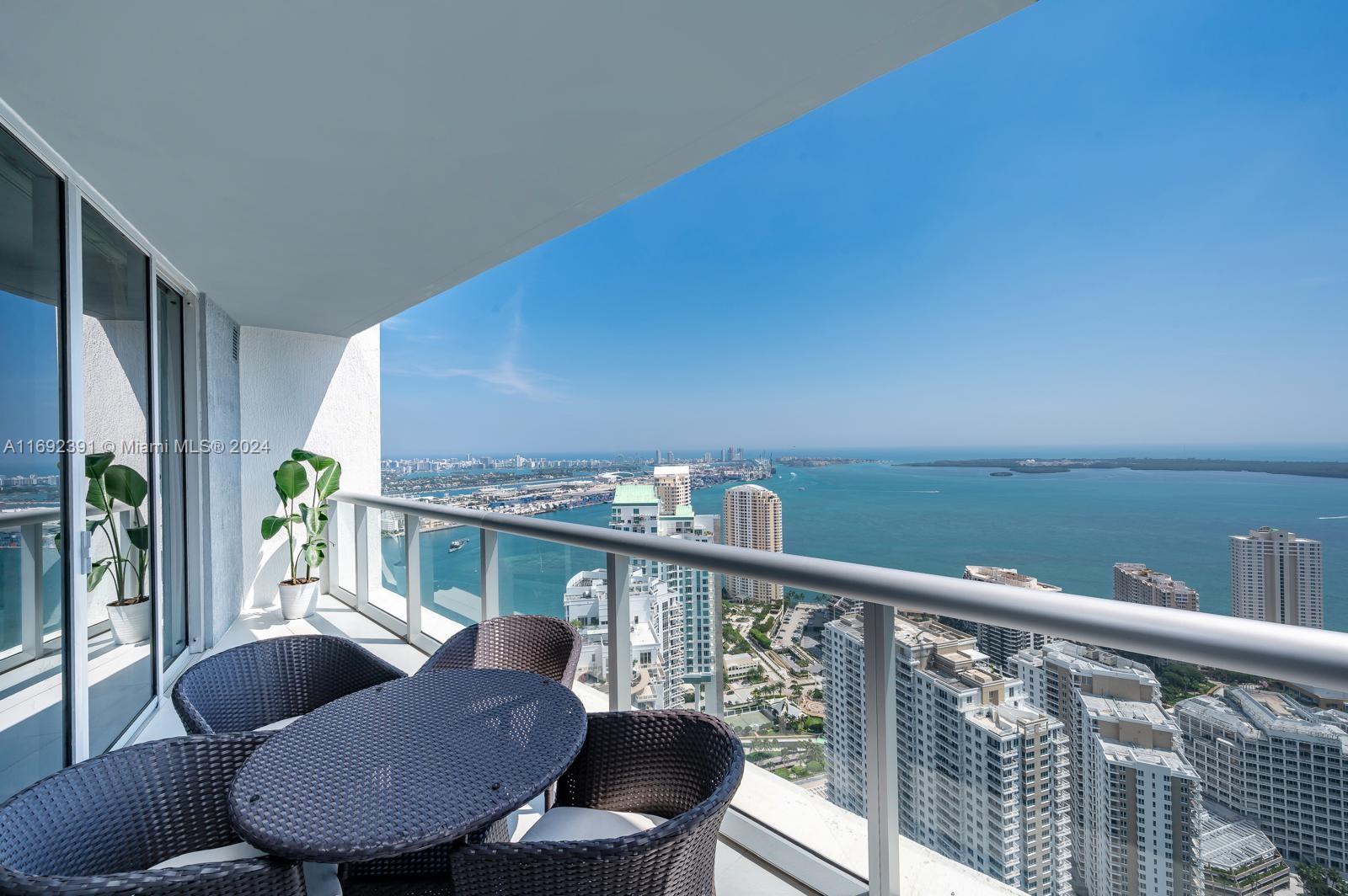 a balcony with wooden floor table and chairs