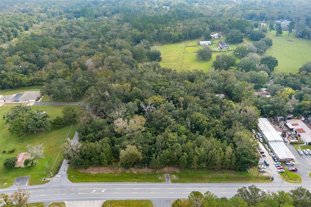 an aerial view of residential houses with outdoor space and lake view