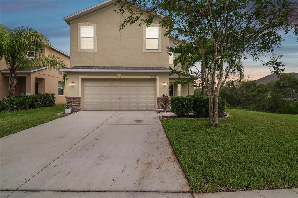 a front view of a house with a yard and garage