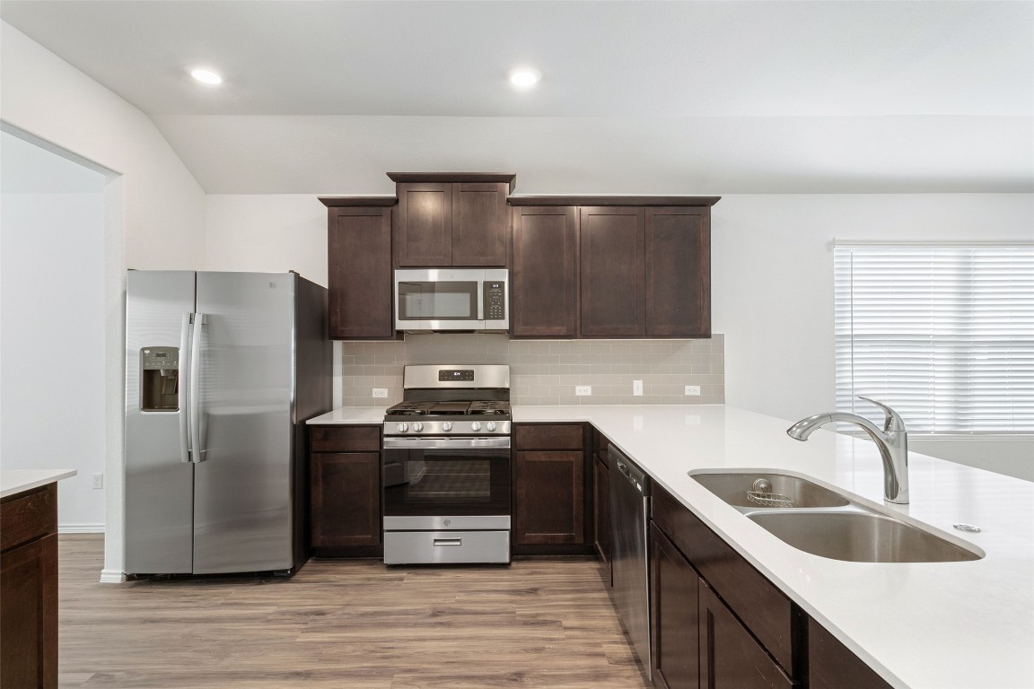 Kitchen equipped with stainless steel appliances including gas range and fridge that conveys