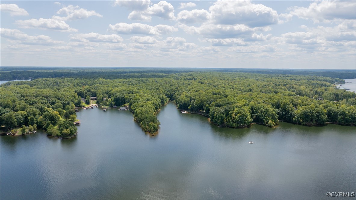 an aerial view of a houses with yard and lake view