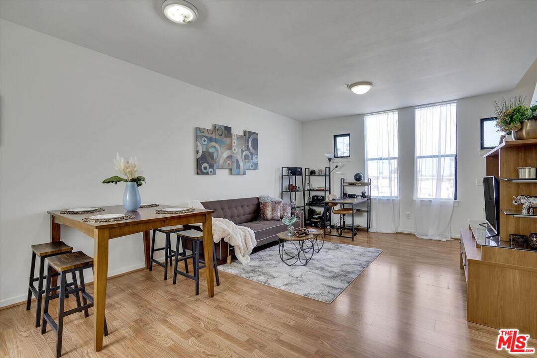 a living room with furniture a flat screen tv and a large window