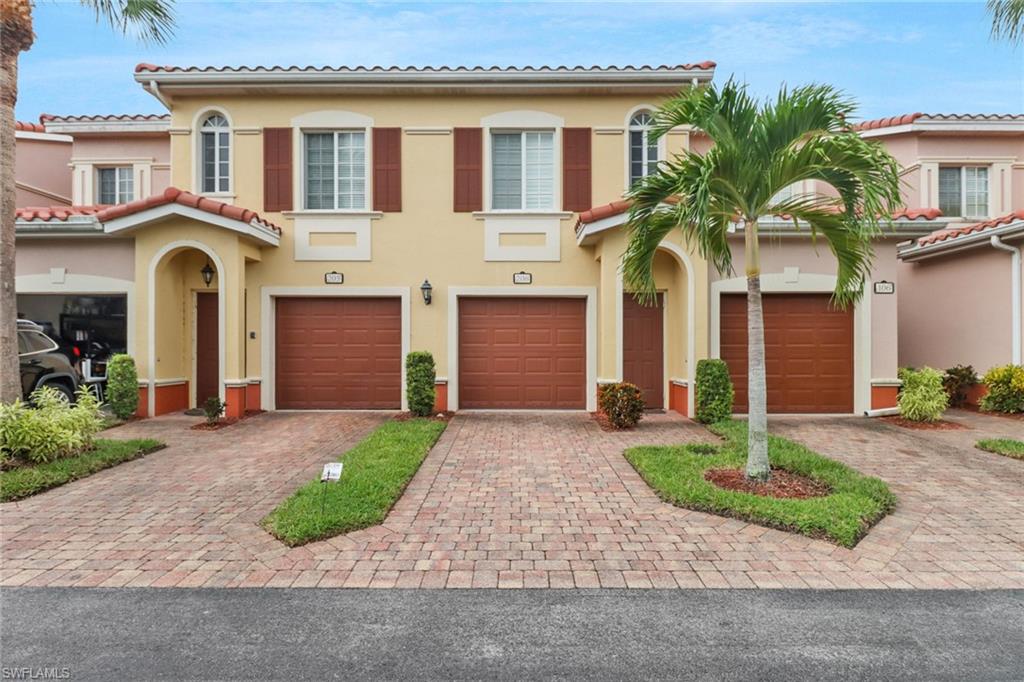 a front view of a house with yard and parking