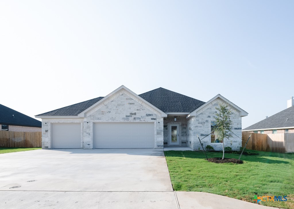 a front view of a house with a garden and yard