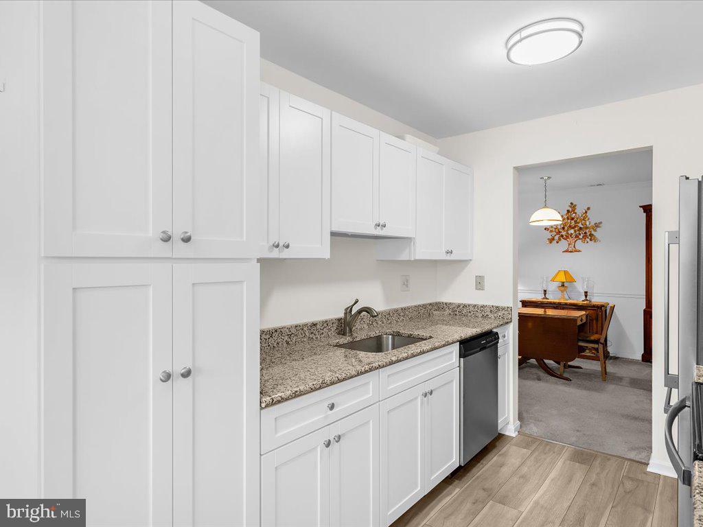 a kitchen with granite countertop white cabinets and stainless steel appliances