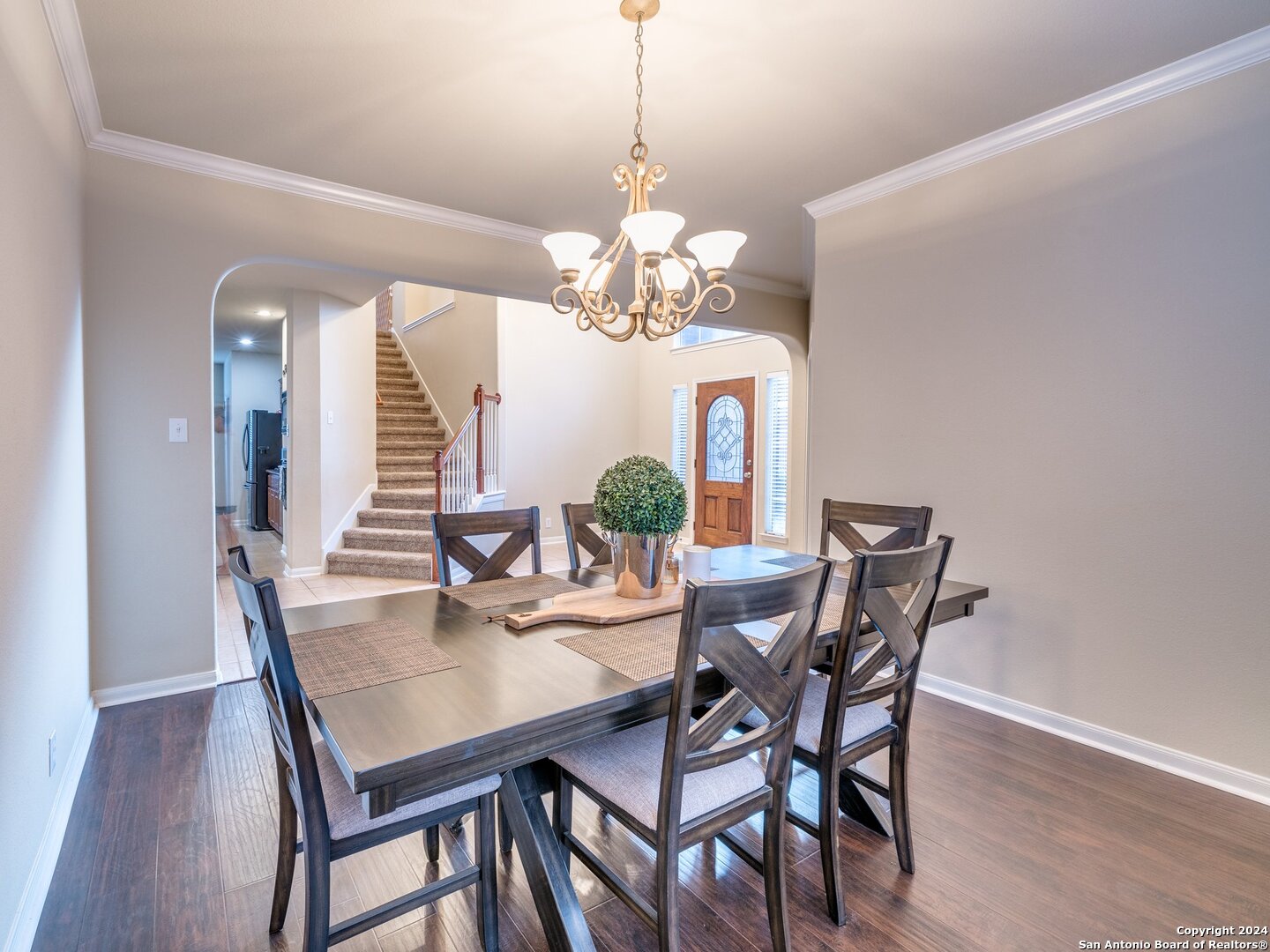 a view of a dining room with furniture a chandelier and wooden floor