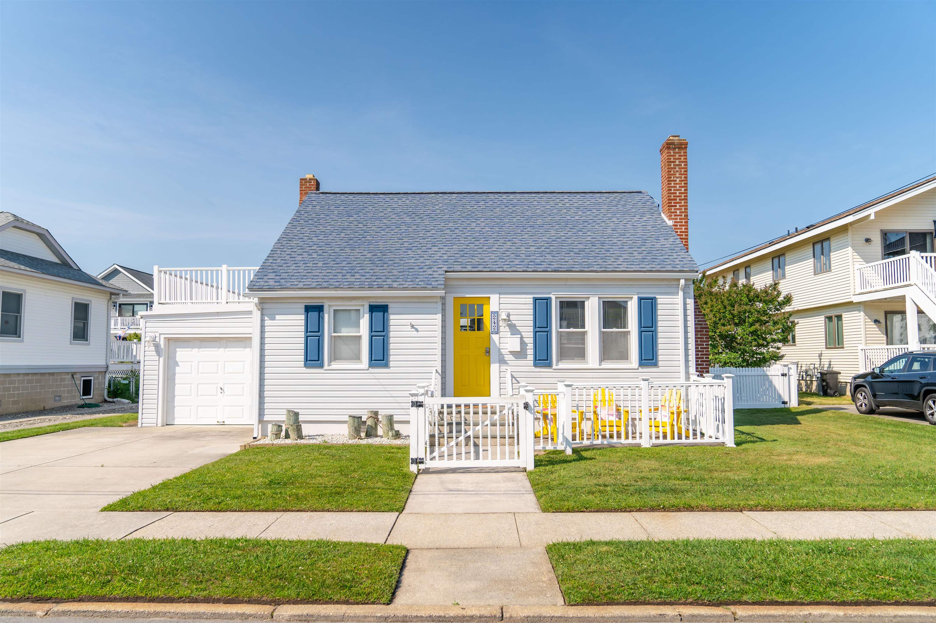 a front view of a house with a yard and outdoor seating