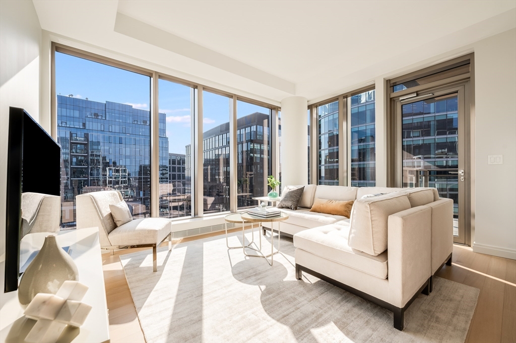 a living room with furniture large windows and a flat screen tv