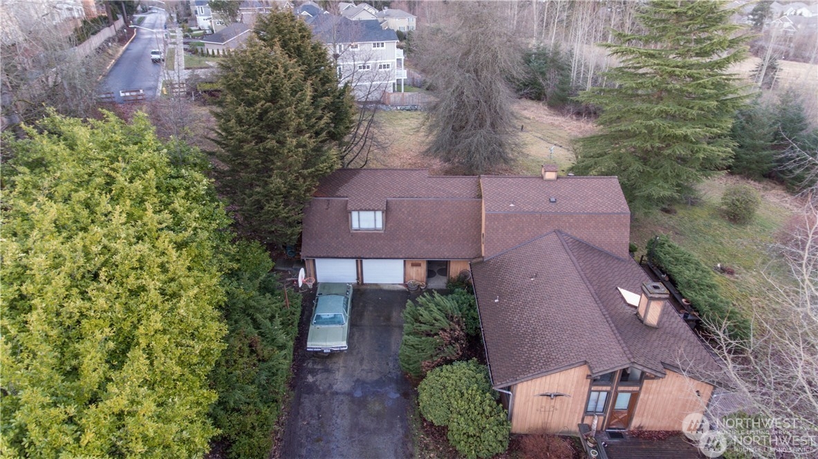 an aerial view of a house with a yard and a large tree