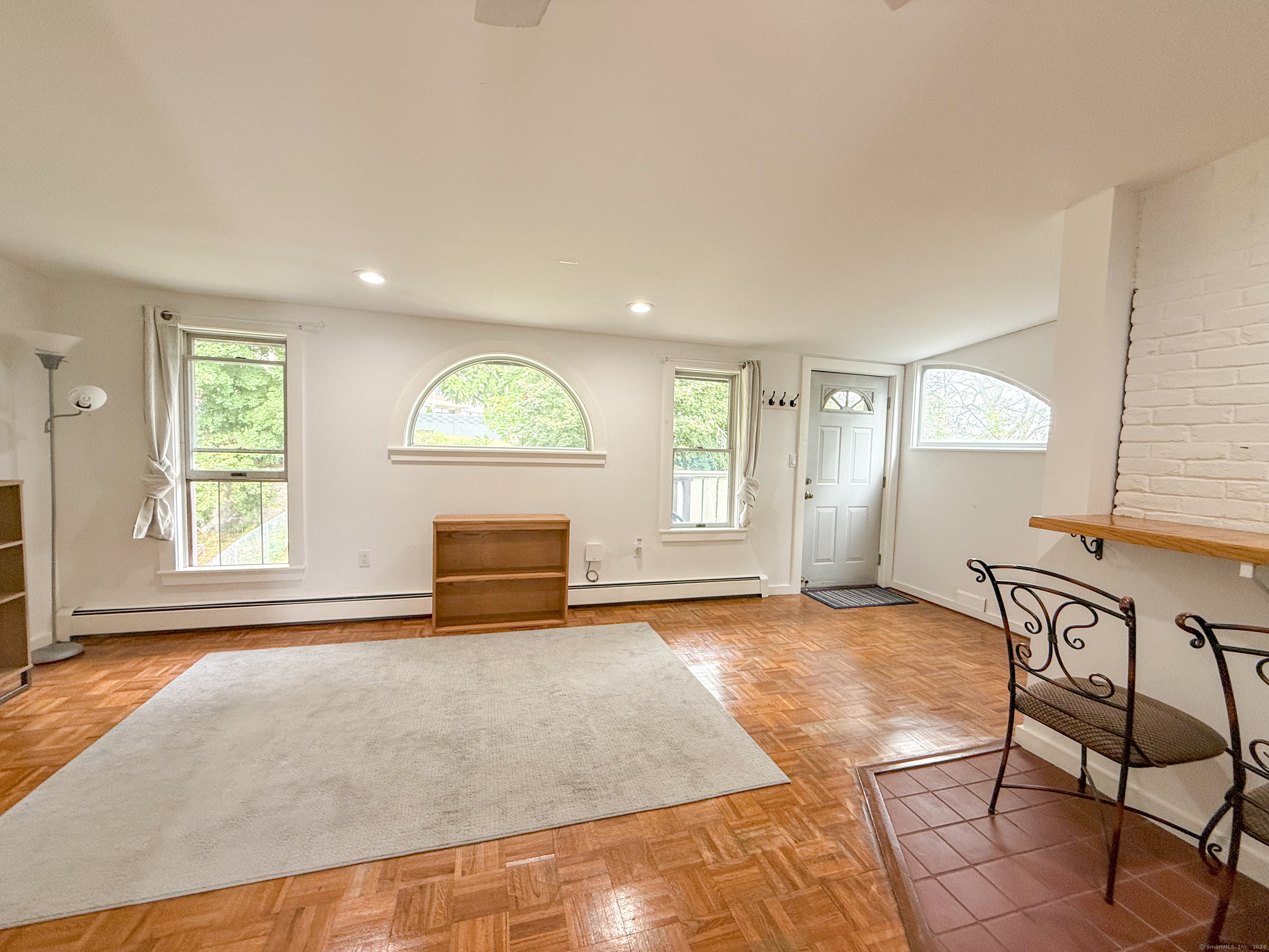 an empty room with windows and fireplace