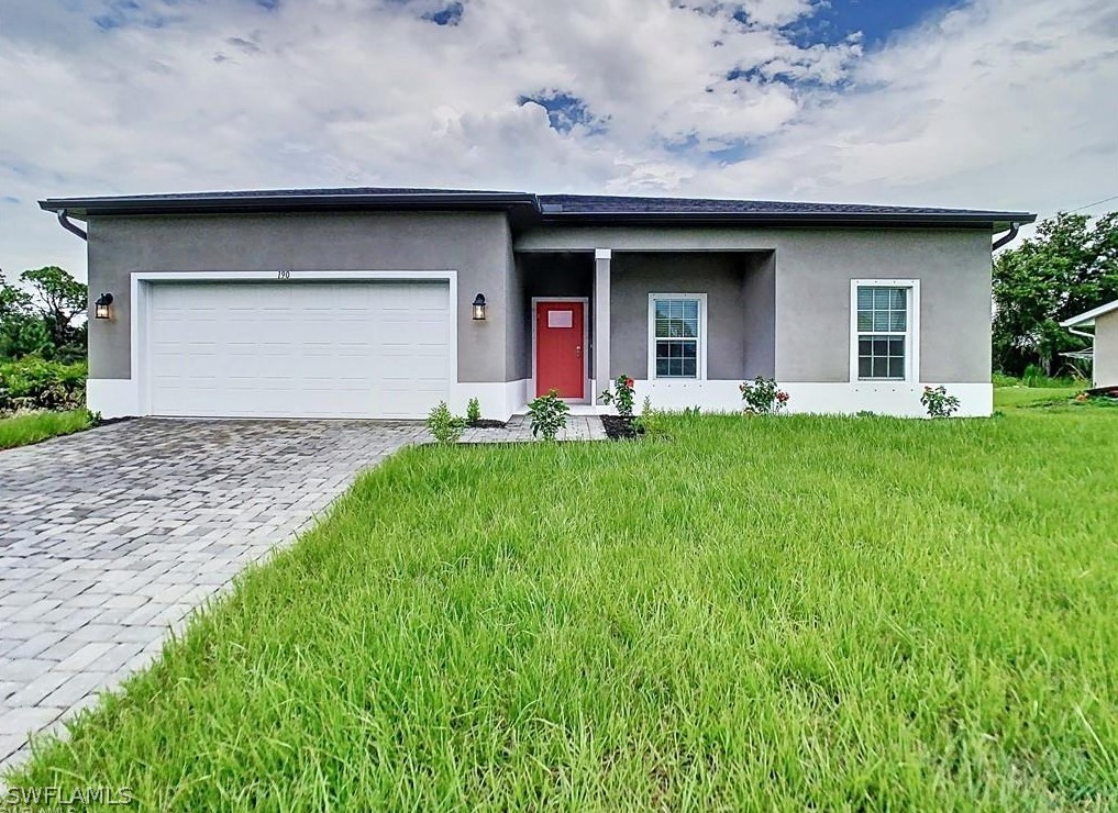 a front view of a house with a garden and yard