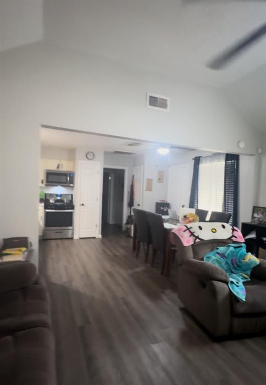 a living room with lots of furniture and a view of kitchen