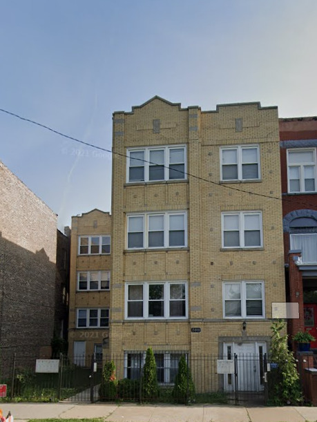 a front view of a residential apartment building with a yard