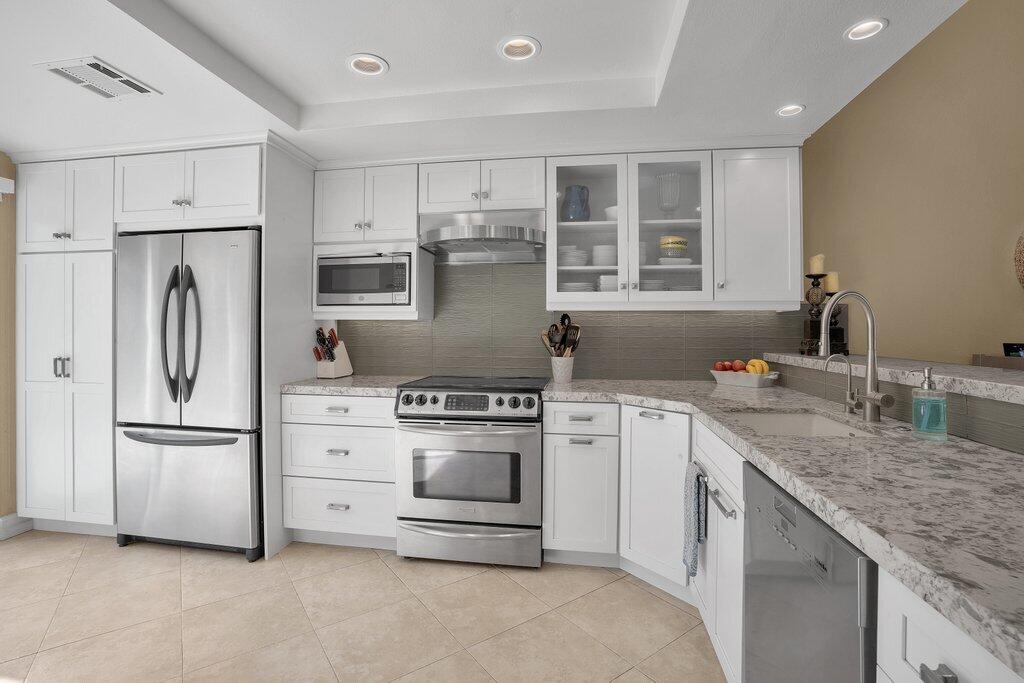 a kitchen with stainless steel appliances granite countertop a refrigerator sink and stove