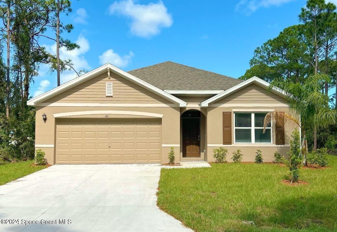 a front view of a house with a yard and garage