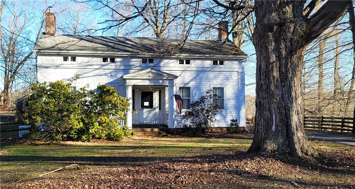 a front view of a house with a yard balcony and trees