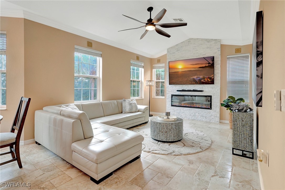 a living room with furniture a flat screen tv and a chandelier