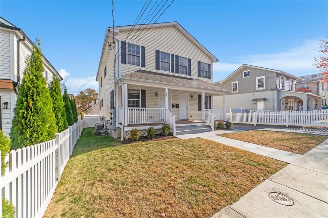 View of property with covered porch and a front lawn