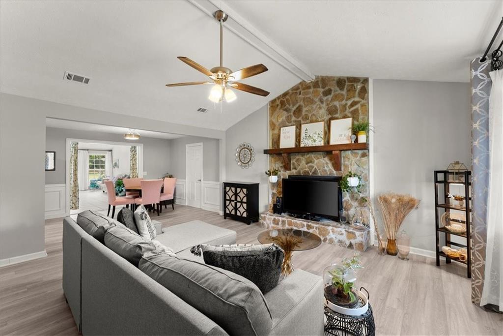 a living room with furniture a fireplace and a flat screen tv