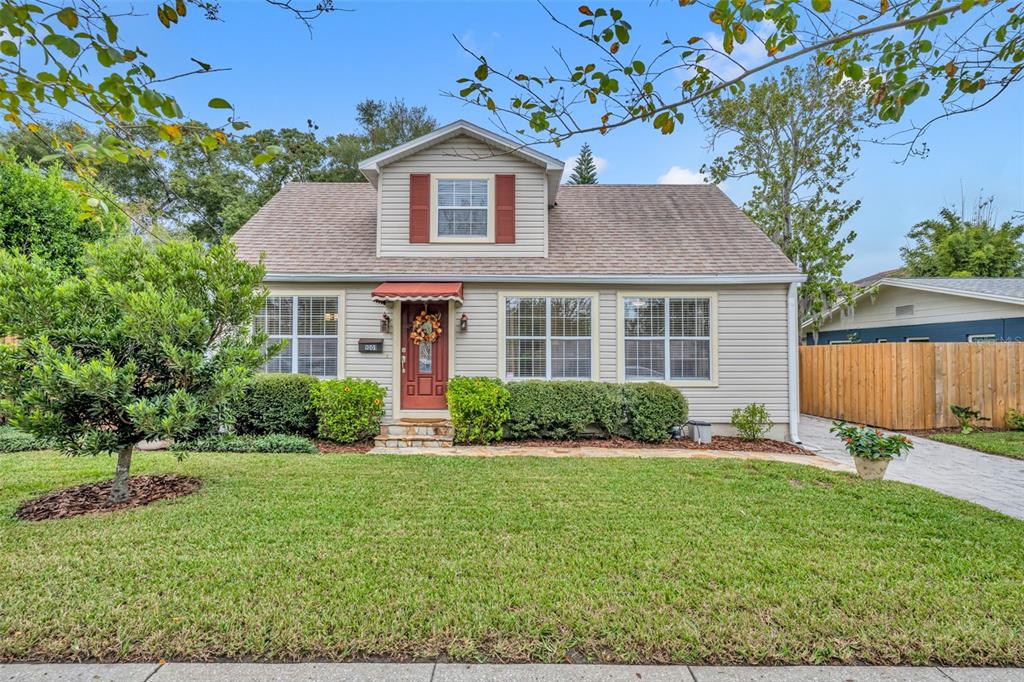 a front view of a house with a yard and potted plants