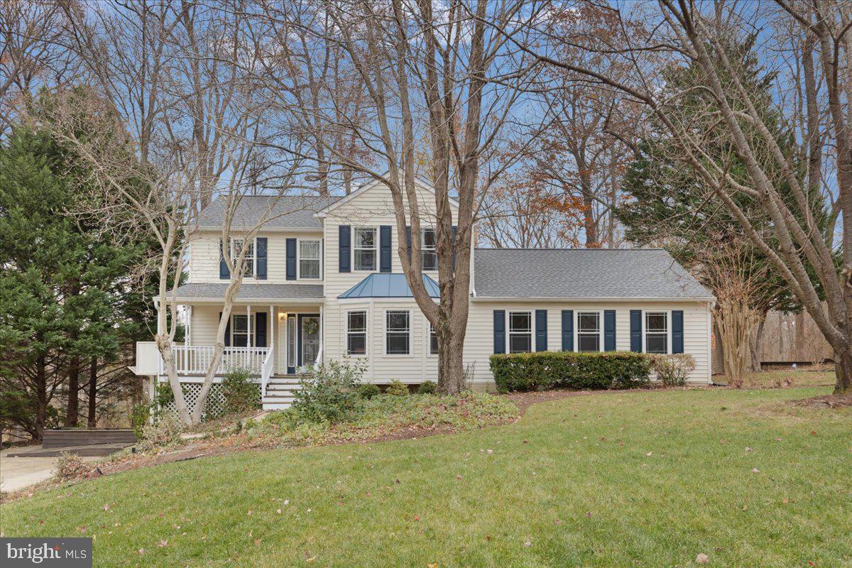 a front view of a house with a garden and trees