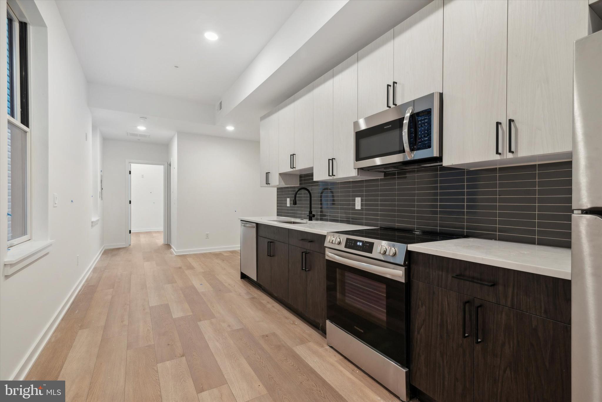 a kitchen with stainless steel appliances kitchen island granite countertop a stove sink and microwave