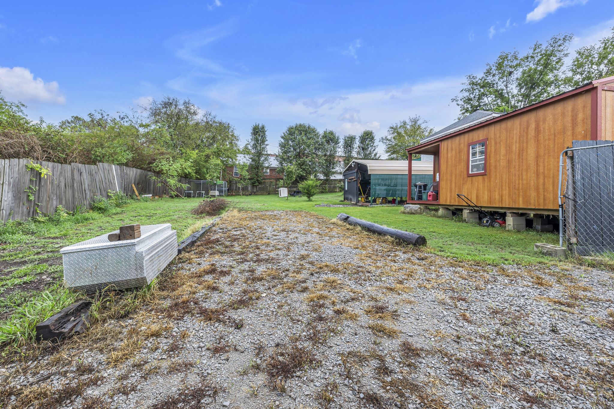 a view of a backyard with plants and wooden fence