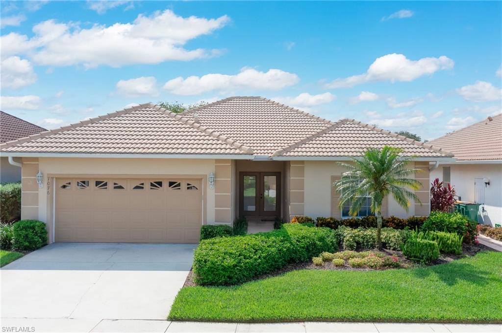 View of front of property featuring a garage and a front yard